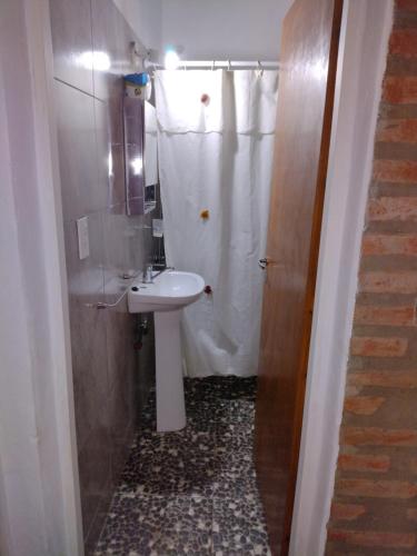 baño con lavabo y cortina de ducha en Cabañas La Peperina 2 in 