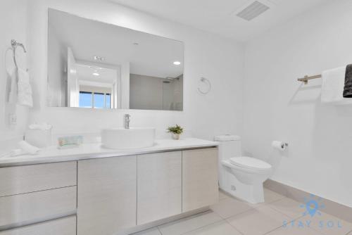 een witte badkamer met een wastafel en een toilet bij Breathtaking 31st Fl Beachwalk Penthouse View in Hallandale Beach