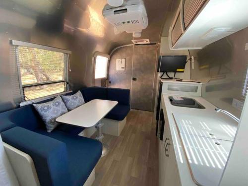 una cabaña con sofá azul y mesa en Modern Airstream with amazing view - 10 to 15 minutes from Kings Canyon National Park, en Dunlap