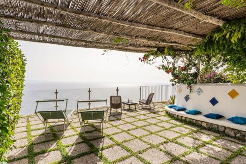 um pátio com cadeiras e vista para o oceano em La casa del '600 Holiday House Amalfi Coast em Amalfi