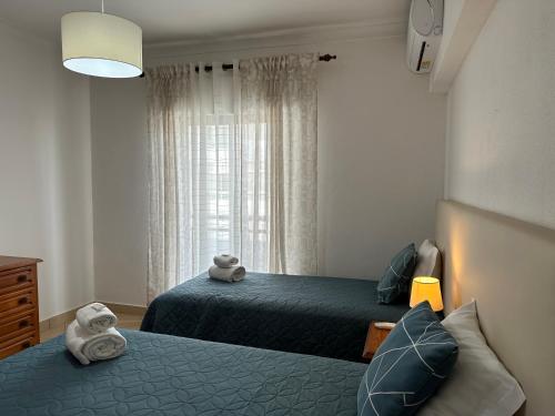 sypialnia z 2 łóżkami i oknem w obiekcie Apartamento Canaima w mieście Quarteira