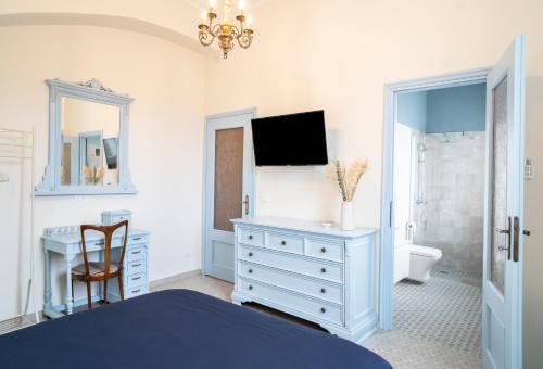 - une chambre avec un lit, un bureau et une télévision dans l'établissement Riobasco, à Albisola Superiore