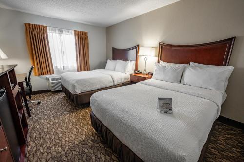 a hotel room with two beds and a television at Christopher Inn and Suites in Chillicothe