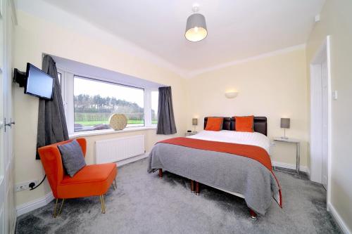 CardestonにあるLower Lodgeのベッドルーム1室(ベッド1台、椅子、窓付)