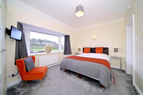 Un dormitorio con una cama y una silla y una ventana. en Lower Lodge, en Cardeston