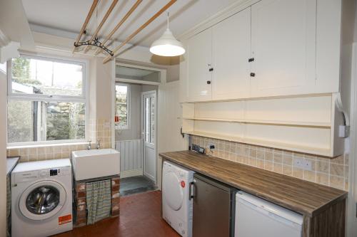 Una cocina con lavadora y secadora. en Llwyn Onn, en Criccieth