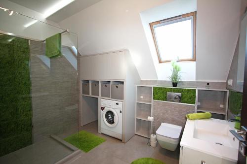 uma casa de banho com uma máquina de lavar roupa e um lavatório em Paloznak Lux Apartmanház em Paloznak