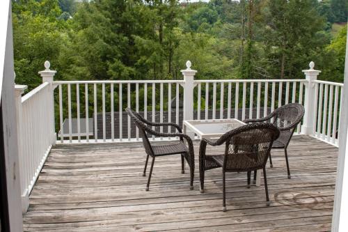 a patio with three chairs and a table on a deck at Elk River Hotel & Cafe in Sutton