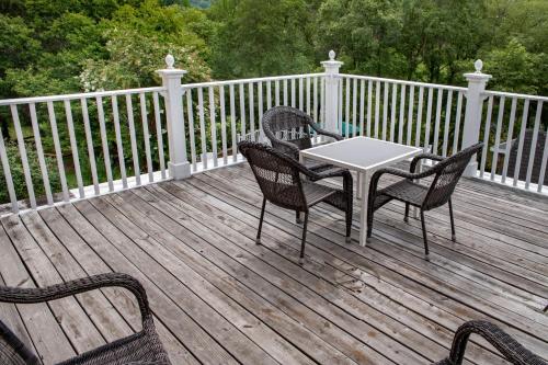 a table and chairs on a wooden deck at Elk River Hotel & Cafe in Sutton