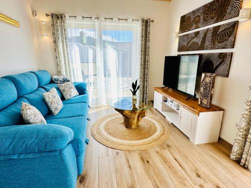 a living room with a blue couch and a tv at Finca Maracuya in El Paso