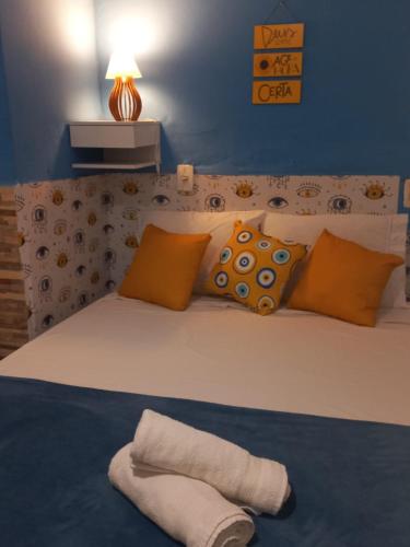 1 dormitorio con 1 cama con almohadas de color naranja y azul en OLHO GREGO Hospedagem em ARRAIAL d'AJUDA, en Arraial d'Ajuda