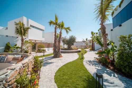 a walkway with palm trees and a building at Nas House Private & Shared Villas in Dubai