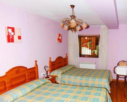 sypialnia z 2 łóżkami i żyrandolem w obiekcie Casa bartolin w mieście Gédrez