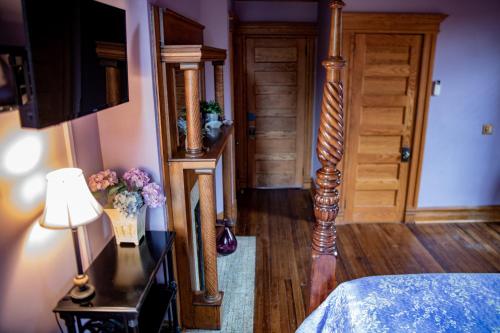 a bedroom with a bed and a table with a lamp at Elk River Hotel & Cafe in Sutton