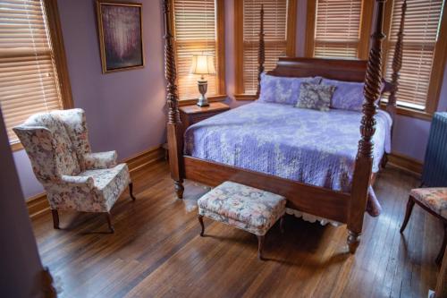 a bedroom with a bed and a chair at Elk River Hotel & Cafe in Sutton