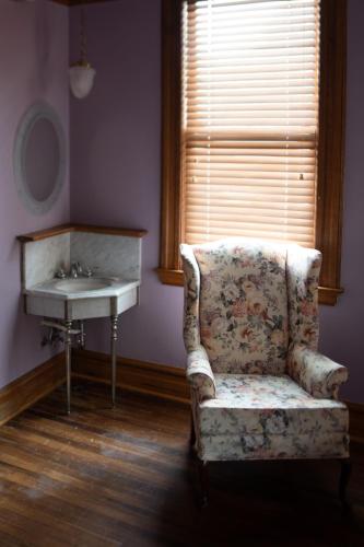 a bathroom with a chair next to a sink and a mirror at Elk River Hotel & Cafe in Sutton
