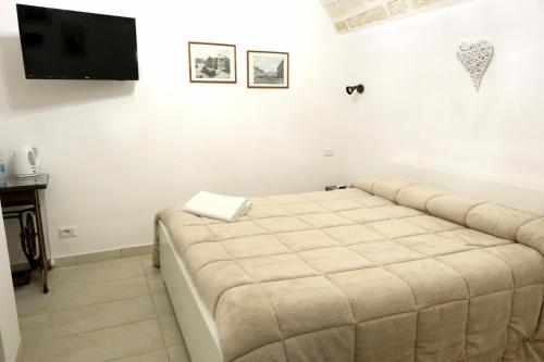 a bed in a room with a tv on the wall at SAN MARCO in Bari