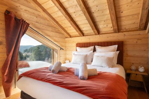 - une chambre avec un lit dans une cabane en rondins dans l'établissement Chalet Tharkey, luxueux au coeur des sapins, à Gérardmer