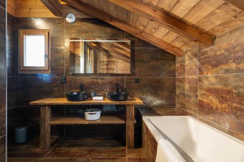 La salle de bains est pourvue de 2 lavabos et d'une baignoire. dans l'établissement Chalet Tharkey, luxueux au coeur des sapins, à Gérardmer