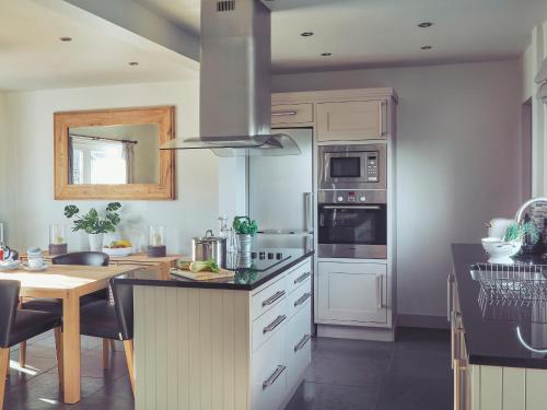 a kitchen with white cabinets and a stove top oven at Craster Reach in Alnwick