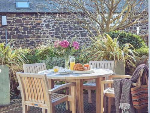 a wooden table with a plate of food on it at Craster Reach in Alnwick