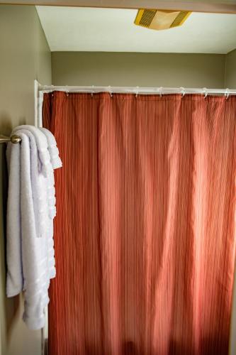 a bathroom with a red shower curtain and a red shower curtain at Elk River Hotel & Cafe in Sutton