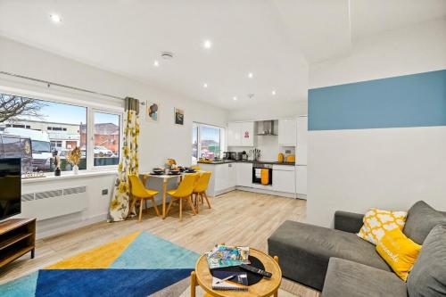 ein Wohnzimmer mit einem Sofa und einem Tisch sowie eine Küche in der Unterkunft May Disc - Long Stay - Contractors in Swindon