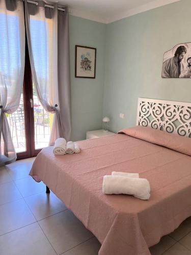 um quarto com uma cama rosa e toalhas em TRILO COPPO CON SPIAGGIA E POSTO AUTO em Numana