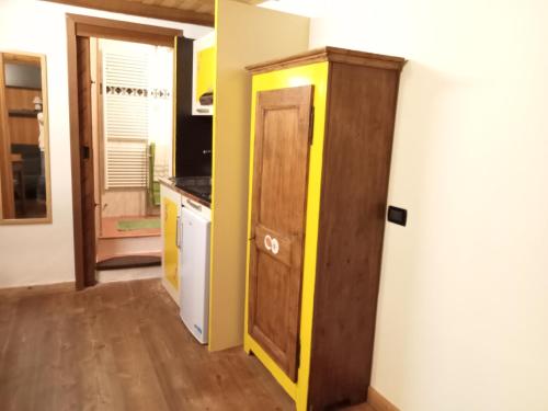 a kitchen with a wooden cabinet and a door at Domy CENTRAL STUDIO in Aosta