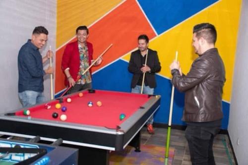 a group of men standing around a pool table at Las Aguas Social Experience in Bogotá