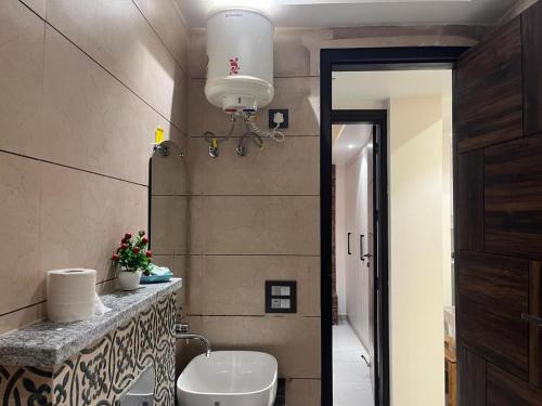 a bathroom with a sink and a toilet in a room at Modern Home 2BHK 3ACs 2Bathrooms Terrace Nr Laxman Jhulla in Rishīkesh