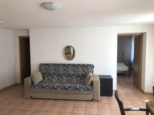 a living room with a couch and a mirror at Vacanza a Miglieglia in Miglieglia