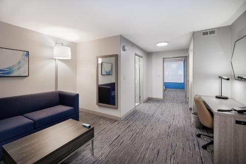 a living room with a blue couch and a table at Holiday Inn Express & Suites Zion by IHG in Zion
