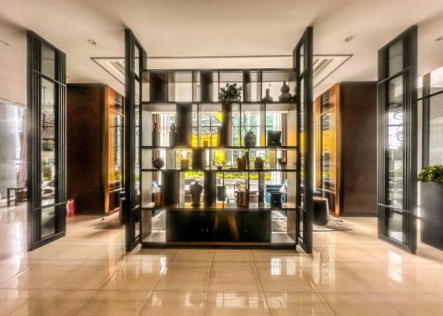 a lobby with a large glass door with vases at Grand Sungkono Lagoon Apartment 2BR Surabaya by Le Ciel Hospitality in Surabaya