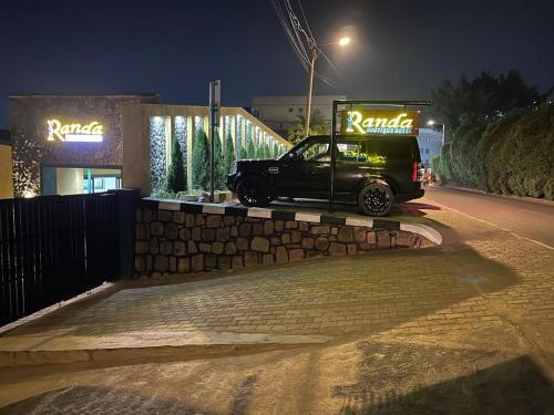 a black van parked on the side of a street at night at Randa Boutique Hotel in Kigali