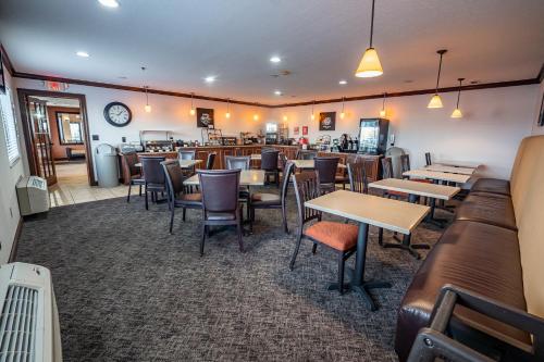 a restaurant with tables and chairs and a bar at Christopher Inn and Suites in Chillicothe