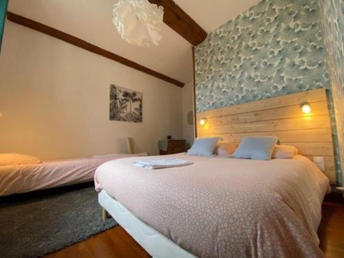 a bedroom with two beds and a headboard at Domaine Des Hêtres in Longraye