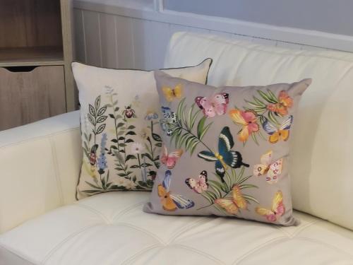 a pillow with butterflies on it sitting on a couch at Hotel Puerta del Lago in Puerto Varas