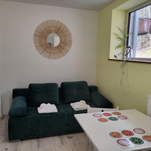 a living room with a green couch and a table at Apartamenty Ustroń Wczasowa 90 in Ustroń