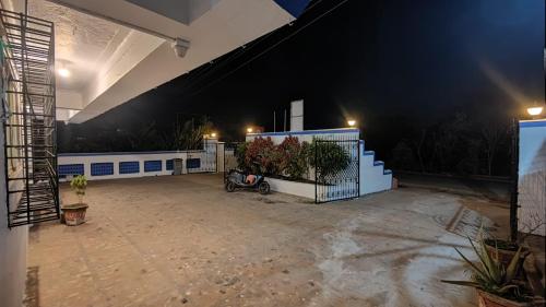 a house with a motorcycle parked in a courtyard at night at Muktai Nest in Alibaug