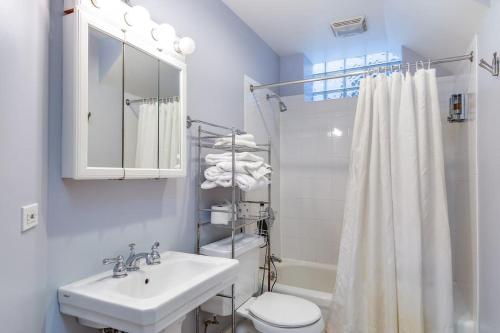 uma casa de banho branca com um lavatório e um WC em Lincoln Park Living - Suite 1 em Chicago