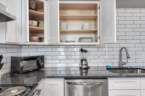 a kitchen with white cabinets and a sink at 713a - Settle in Historic Soulard in Soulard