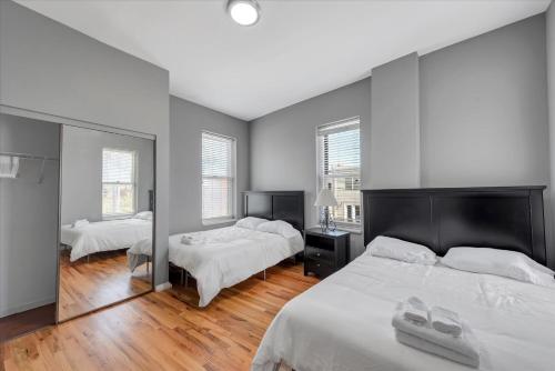 a bedroom with two beds and a large mirror at 713a - Settle in Historic Soulard in Soulard