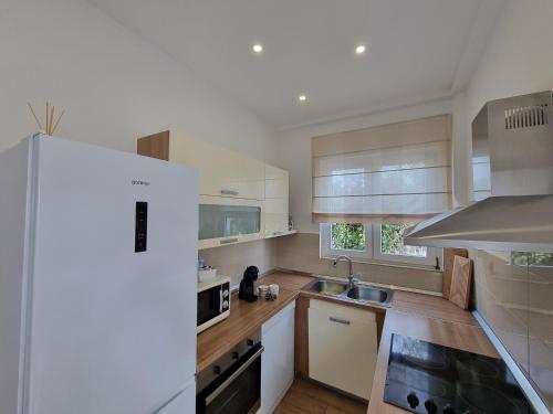 a kitchen with white cabinets and a sink at Apartment Lučka in Rab