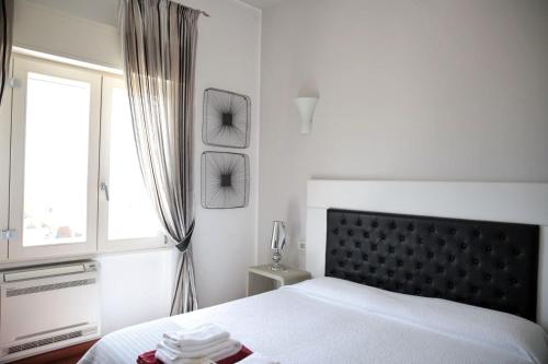 a white bedroom with a bed and a window at Villa Maria Luisa in Cagliari