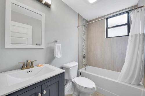 een witte badkamer met een wastafel en een toilet bij Stunning Townhome 916 in The Grove in Tower Grove