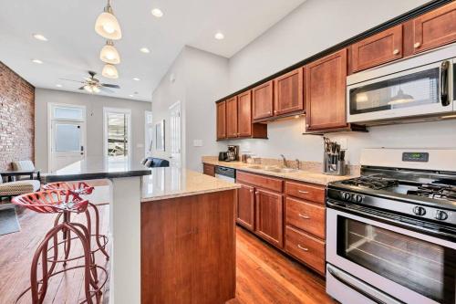 a kitchen with wooden cabinets and a stove top oven at St Louis Townhome-Perfect for Groups in Tower Grove