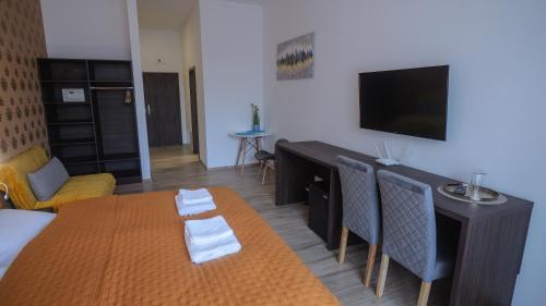 a living room with a bed and a table and a television at Premium City Centre Bedrooms in Prešov