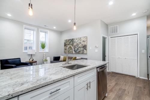 a kitchen with a sink and a living room at 2 New Construction Suites Same Place in Chicago