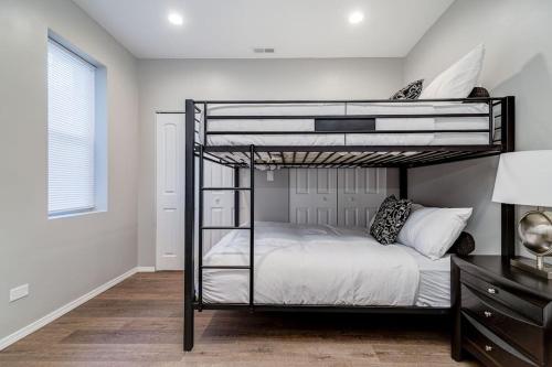 una camera con letto a castello e lenzuola bianche di 2 New Construction Suites Same Place a Chicago